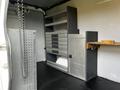 Interior of a 2017 Mercedes-Benz Sprinter with metal shelving units and drawers for storage