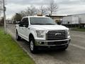 A white 2017 Ford F-150 pickup truck parked on the side of a street with chrome accents and a silver grille