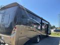 A 2008 Newmar Canyon Star 36 Foot Class A Motorhome with a sleek exterior in black and gold colors featuring large windows and a slide-out section on the side