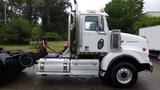 A 2019 Western Star Trucks 4900 with a white exterior and chrome accents is parked with its side profile visible showcasing the cab and chassis design