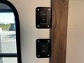 Image shows two black toggle switches mounted on a wall with a wooden frame one switch is labeled ON and the other OFF