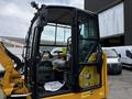 A 2024 Caterpillar 306 excavator with a yellow exterior and black cab featuring a transparent window and an interior display with a seat and controls