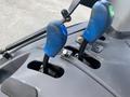 Close-up of the control levers of a 2016 New Holland T475 tractor featuring two blue joystick handles designed for operational controls