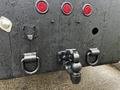 Close-up of the rear of a 2017 Ford F-550 showing red tail lights a hitch and mounting points with a dark wet finish