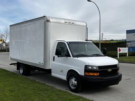 A 2019 Chevrolet Express cargo van with a white box cargo area is parked on the side of the road