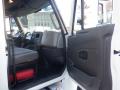2014 International Durastar interior showing the driver's seat dashboard and open door with a red toolbox visible on the floor