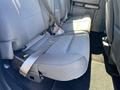 A gray upholstered back seat of a 2019 Ford F-150 with seatbelts fastened showing a comfortable seating area