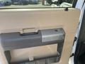 The interior door handle of a 2014 Ford F-350 SD with a beige panel and a grey handle