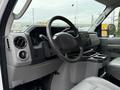 Interior view of a 2019 Ford Econoline showing the steering wheel dashboard and center console with storage compartments