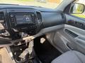 Interior of a 2015 Toyota Tacoma featuring a dashboard with touchscreen display climate controls and a gear shift console