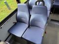 Two blue upholstered seats in a vehicle with a simple design and seating belts