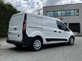 A white 2014 Ford Transit Connect van parked with sliding side doors and silver wheel rims