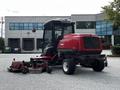 A red 2012 Toro Groundsmaster with a heavy cutting deck and a protective cab for operators