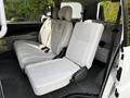Interior view of a 2003 Mitsubishi 7 Passenger Van showing the second row of seats with light upholstery and two captain's chairs in a reclined position