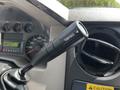 A close-up of the tow-haul switch located on the gear shift of a 2009 Ford F-550 truck showing a black lever with the label tow-haul