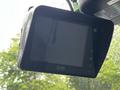 A digital display monitor mounted on the windshield of a 2013 Ford Econoline showing a blank screen and control buttons