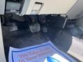 A close-up view of the pedals in a 2013 Ford Expedition showing the brake and accelerator pedals along with a floor mat that reads We Take Pride In Your Vehicle