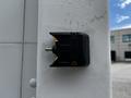 A black and yellow switch mounted on a white post with a metal knob in the center and two visible screws on its sides