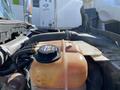 Close-up of a coolant reservoir with labeled cap and hoses attached on a 2014 International 7400 engine compartment
