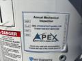 A 2016 Ford F-550 truck with a sign indicating an annual mechanical inspection schedule and contact information for Apex Heavy Duty and Aerial Repair