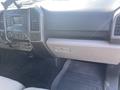 The interior dashboard of a 2017 Ford F-150 featuring controls for audio and climate and a storage compartment on the passenger side
