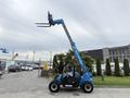 A blue 2020 Genie GTH-5519 telehandler with a raised boom and fork attachment positioned in an industrial area
