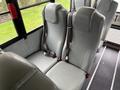 Two gray bus seats with seat belts, designed for safety, positioned in a row with a clean and simple design