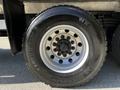 A close-up view of a Michelin tire mounted on a steel wheel of a 2005 Volvo VND 122 featuring five lug nut holes and a distinctive tread pattern