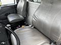 Interior of a 2017 International WorkStar 7600 featuring two gray leather seats and a black dashboard with controls and storage compartments