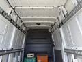 Interior of a 2016 Mercedes-Benz Sprinter van showing empty cargo space with metal shelving and some storage crates in the foreground