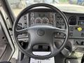 The interior of a 2016 Freightliner 108SD featuring a steering wheel with controls a dashboard with various gauges and displays and floor pedals