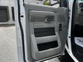 Door panel of a 2018 Ford Econoline featuring a textured gray finish with a handle and a speaker area