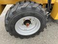 Close-up of a tire on a 2024 AGT Industrial KRW23 Mini Loader featuring deep treads and a metallic rim with a central hub securely fastened with bolts