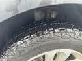 Close-up of a wet tire on a 2016 Ford Explorer showing deep tread patterns and details of the rim