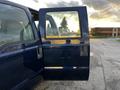 A blue 2008 Ford F-250 SD with the driver's door open showing the interior and a reflection of the surroundings