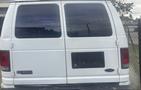 A white 2002 Ford Econoline van with a rear view showing windows and a space for a license plate.