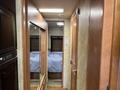 A 2008 Newmar Canyon Star 36 Foot Class A Motorhome interior hallway with mirrored cabinet doors leading to a bedroom with a bed covered in a blue blanket