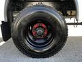 Close-up of a large black tire mounted on a wheel with a red hubcap showcasing the brand name Michelin and tire specifications 11R22.5