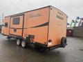 2015 Winnebago of Indiana travel trailer in orange with a design featuring the name Minnie and a distinctive W logo on the side