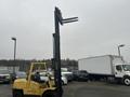 A yellow 2000 Hyster 120 forklift with raised forks in a parking lot