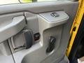 Interior door handle and controls of a 2017 GMC Savana with a manual window crank and power window switch