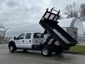 A 2015 Ford F-550 dump truck with an elevated bed, showcasing a flatbed design ideal for transporting and unloading materials