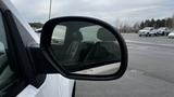 A side mirror of a 2013 Chevrolet Silverado 1500 reflecting a portion of the interior and showing raindrops on the surface