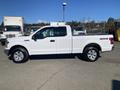 A 2019 Ford F-150 pickup truck in white with a standard cab and a bed featuring chrome wheels and a 4x4 emblem on the side