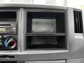 Dashboard of a 2018 Isuzu NPR featuring empty storage compartments and controls for air conditioning and audio system