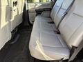 The image shows the back seat of a 2020 Ford F-550 with light gray upholstery and three seat cushions with seat belts