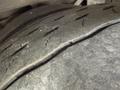 A close-up of a worn tire showing deep cracks and tread wear typical of heavy usage on a vehicle