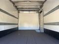 Empty interior of a 2013 Isuzu NPR box truck with wooden flooring and metal walls