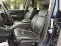 Interior view of a 2013 Dodge Journey showing black leather front seats and center console with storage compartments
