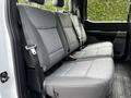 Interior view of a 2024 Ford F-550 showing the back seat with gray fabric upholstery and seatbelts